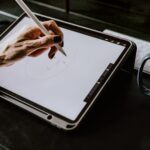 person holding white ipad with black case